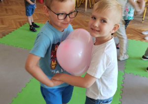 Chłopcy tańczą z balonem
